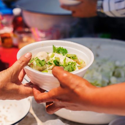 image of a bowl of food being passed from one person to another