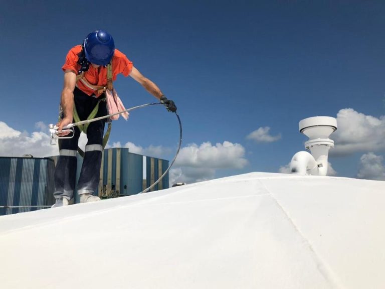 image of a person applying mascoat protective coating with a jet spray to a roof to prevent corrosion and vapour loss.